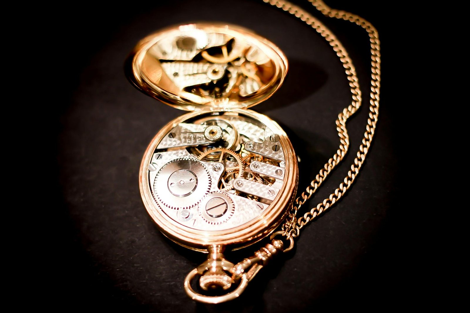 Close-up of an open gold pocket watch revealing its intricate mechanical gears.