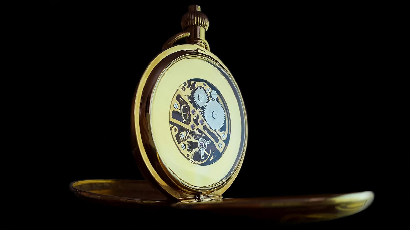 Close-up of an open pocket watch showing intricate gears, symbolizing precision and elegance.
